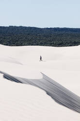 Distant View Of Man Walking On Sand During Sunny Day - EYF01316