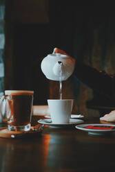 Cropped Hand der Frau gießt Wasser in Kaffee - EYF01331