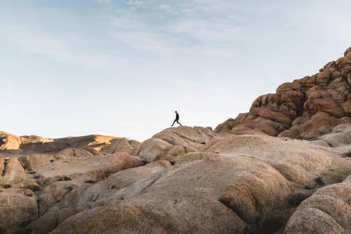 Low Angle View Of Man Walking On Rocky Mountain gegen Himmel - EYF01385