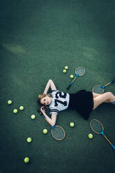 High Angle View Of Tired Young Woman Lying On Court - EYF01417
