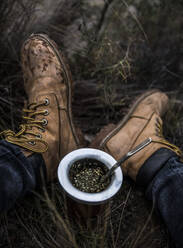 Niedriger Ausschnitt einer auf dem Feld sitzenden Person mit Schuhen - EYF01465