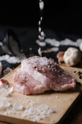 Nahaufnahme von Fleisch mit Salz auf Schneidebrett - EYF01480