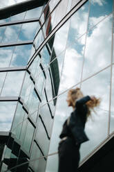 Low Angle View Of Unrecognizable Woman Walking On Glass Window - EYF01513