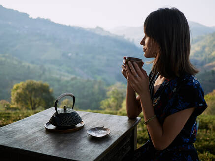 Woman Drinking Tea In Garden - CAVF77431