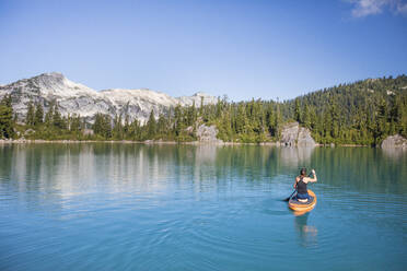 Attraktive Frau paddelt Stand up Paddle Board auf blauem See. - CAVF77438