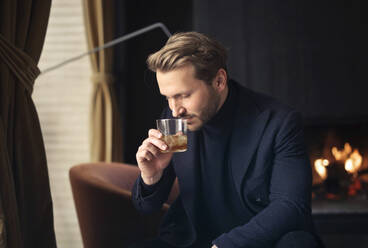 Gutaussehender Mann trinkt einen Whisky - CAVF77487