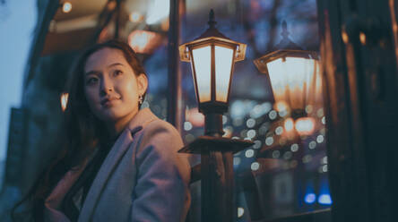 Asiatische Frau auf der Straße in der Nacht - CAVF77493