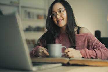 Asiatische Frau lächelnd mit einem Laptop - CAVF77505