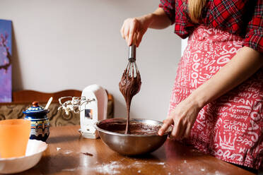 Der Prozess des Mischens und der Zubereitung von Schokoladen-Cupcakes durch eine junge Frau - CAVF77506
