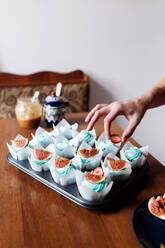 Hausgemachte Schokoladenmuffins mit blauem Sahnebelag und Feigen dekorieren - CAVF77524