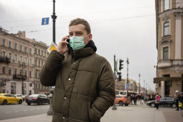 Young man with face mask, commuting in the city, St. Petersburg, Russia - VPIF02122