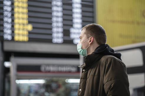 Young man with face mask at train station in the city - VPIF02125