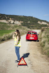 Woman having a breakdown in the countryside talking on the phone - OCMF01076