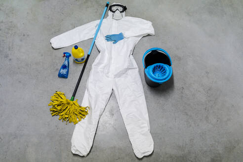 Schutzkleidung, Reinigungsmittel, Eimer und Desinfektionsmittel liegen auf dem Boden - DLTSF00634