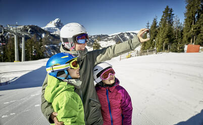 Mother with her children, taking a selfie on ski slope - DIKF00388