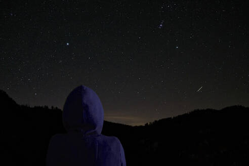 Rückansicht einer Frau mit Blick auf den nächtlichen Sternenhimmel - DIKF00393