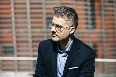 Portrait of a gray-haired businessman in the city looking around - JRFF04216