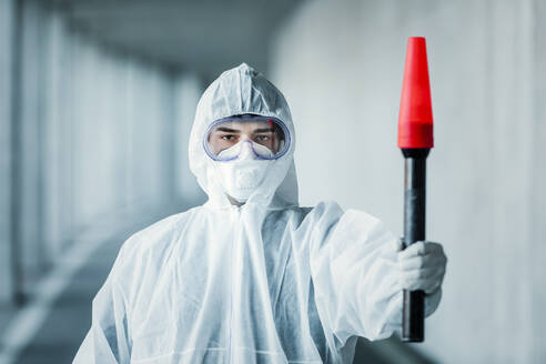 Portrait of man wearing protective clothing holding a signaling disk - WVF01477
