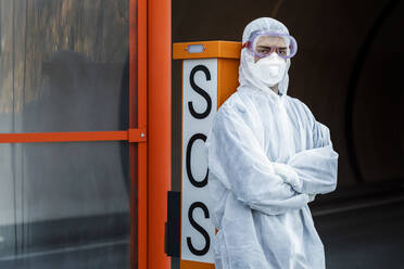 Portrait of man wearing protective clothing leaning against SOS telephone - WVF01515