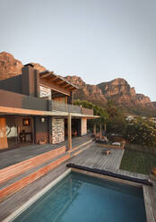 Mountains behind modern, luxury home showcase exterior house with swimming pool - HOXF05229