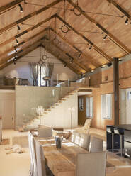 Home showcase interior dining room with wood vaulted ceiling and spiral staircase loft - HOXF05248