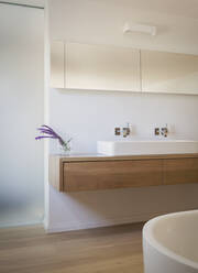 Modern white bathroom with purple flowers in vase - HOXF05252