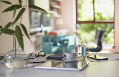 Digital tablet on table with coffee and calculator - HOXF05322