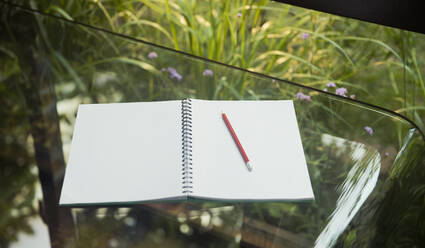 Open blank notebook and pencil on glass table - HOXF05328