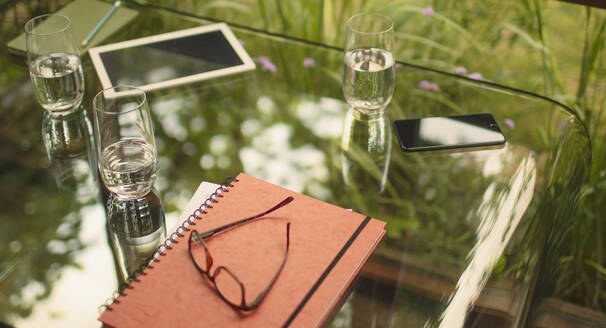 Brille und Notizbuch auf dem Tisch mit digitalem Tablet und Smartphone - HOXF05335