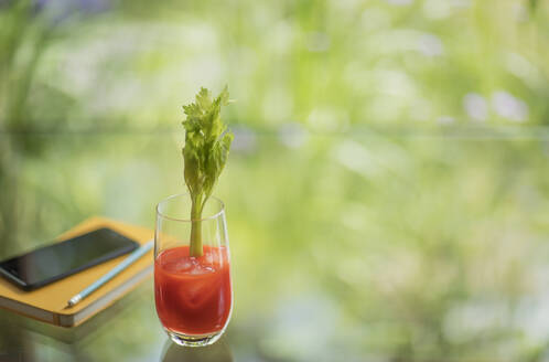 Bloody-Mary-Cocktail mit Stangensellerie auf dem Tisch - HOXF05351