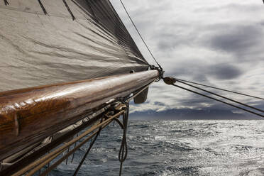 Wooden ship mast and sail over sunny Atlantic Ocean - HOXF05361