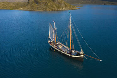 Schiff in Bucht auf sonnigem blauen Ozean Grönland - HOXF05371