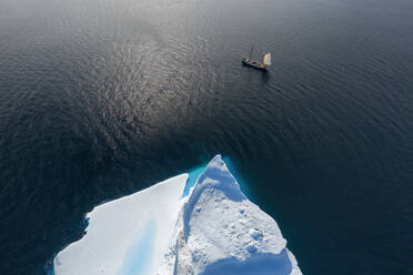 Drone Sicht Schiff Segeln vorbei Eisberg auf sonnigen Ozean Grönland - HOXF05382