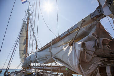 Sailboat sails and rigging under sunny blue sky - HOXF05415