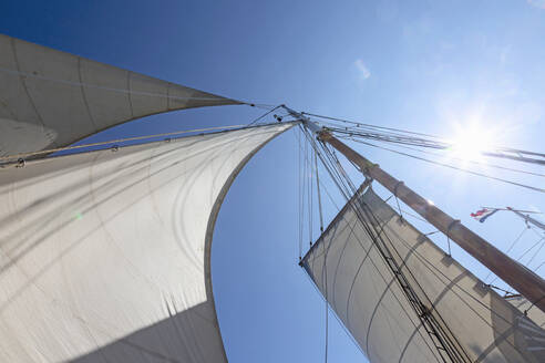 Segelboot Segel weht im Wind unter sonnigen blauen Himmel - HOXF05433
