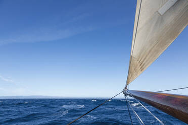 Wooden sailboat mast over sunny blue Atlantic Ocean - HOXF05434