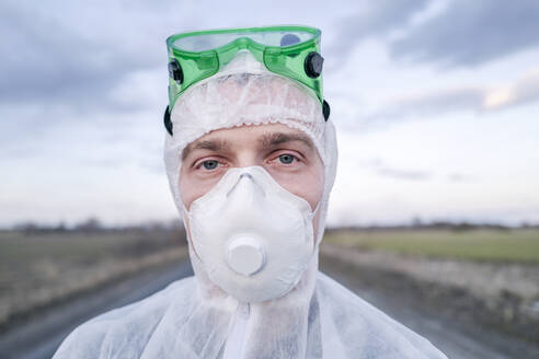 Portrait of man wearing protective suit and mask - EYAF00974