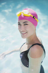 Porträt selbstbewusste Frau mit Badekappe und Schwimmbrille im Schwimmbad - HOXF05501