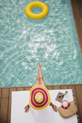 Woman in sun hat relaxing, sunbathing at summer poolside - HOXF05516