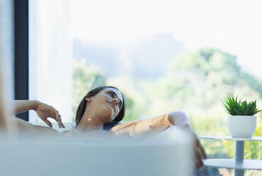 Gelassene Frau entspannt in der Badewanne - HOXF05541