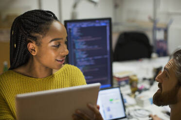 Computerprogrammierer mit digitalem Tablet im Gespräch im Büro - HOXF05644