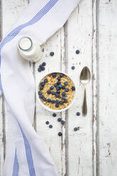 Milk bottle, napkin and bowl of muesli with blueberries - LVF08678