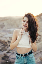 Portrait of smiling young woman with headphones in nature, Almeria, Spain - MPPF00659