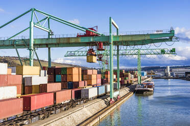 Germany, Baden-Wurttemberg, Stuttgart, Cargo containers stacked in commercial dock on bank of Neckar river - WDF05868