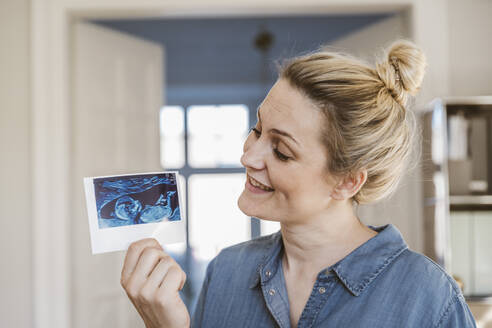 Schwangere Frau hält Ultraschallbild zu Hause - MFF05108