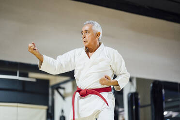 Älterer Mann übt Karate im Fitnessstudio - OCMF01087