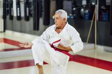 Älterer Mann übt Karate im Fitnessstudio - OCMF01091