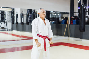 Älterer Mann übt Karate im Fitnessstudio - OCMF01092