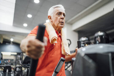 Senior man practising at stepper in gym - OCMF01096