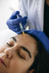 Woman receiving hyaluronic acid injection in medical practice - ABZF03010